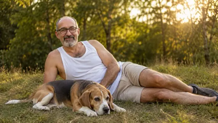 Cuánto ejercicio necesita un beagle. Adfer Dazne descansando con su beagle, al aire libre.